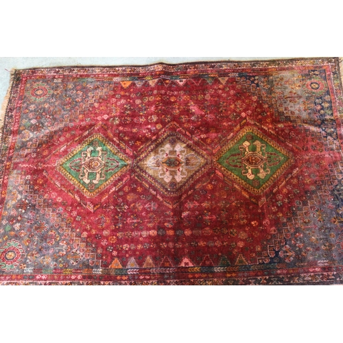 5 - Qashqai rug with a triple medallion design on a wine red ground with corner designs and narrow borde... 