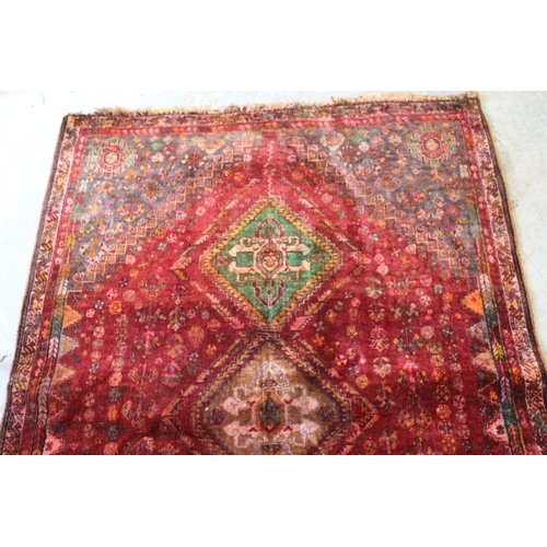 5 - Qashqai rug with a triple medallion design on a wine red ground with corner designs and narrow borde... 