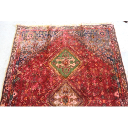 5 - Qashqai rug with a triple medallion design on a wine red ground with corner designs and narrow borde... 