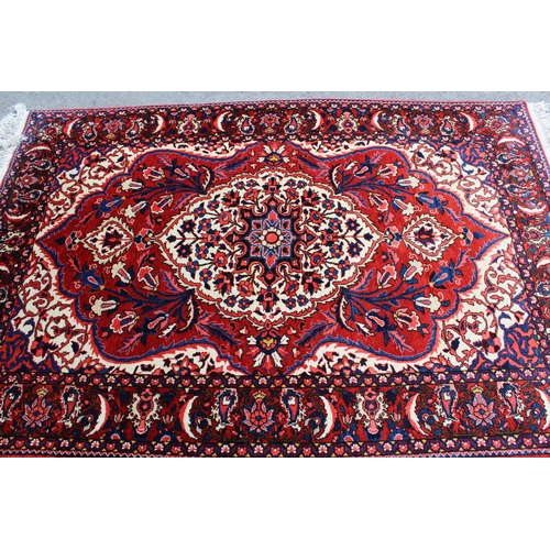 52 - Bakhtiari rug with a medallion and all-over floral design on a red ground with ivory corner designs ... 