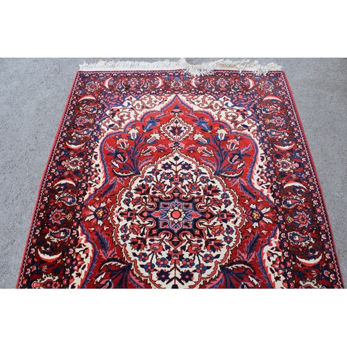 52 - Bakhtiari rug with a medallion and all-over floral design on a red ground with ivory corner designs ... 