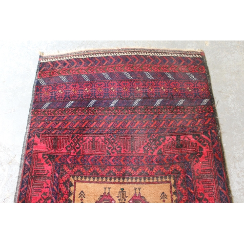 56 - Belouch rug with a single medallion design on a banded red ground, 5ft 6ins x 3ft approximately