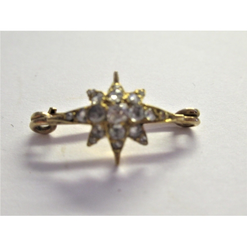 909 - Miniature yellow metal and rose cut diamond set star form brooch, overall width 25mm approximately