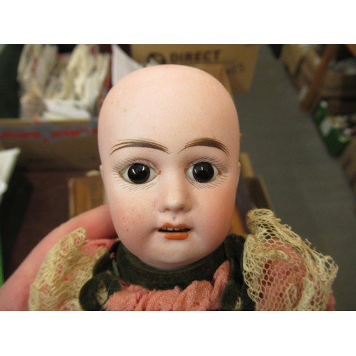 199 - Small late 19th / early 20th Century bisque headed doll with fixed eyes and kid leather body, wearin... 