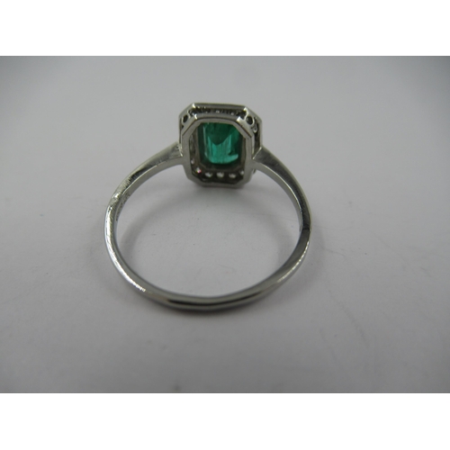 1121 - Platinum ring set with central octagonal emerald surrounded by diamonds, size N