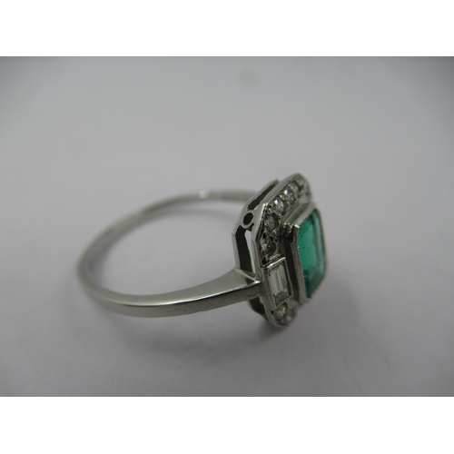 1121 - Platinum ring set with central octagonal emerald surrounded by diamonds, size N