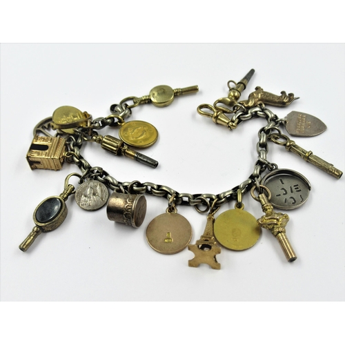 1328 - Silver charm bracelet with various silver gilt and silver charms and six watch keys