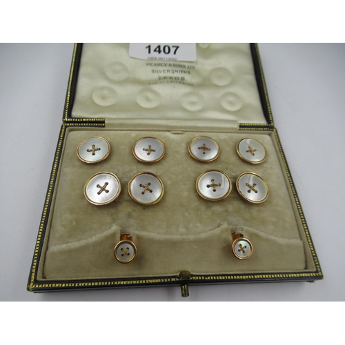 1407 - Cased set of six early 20th Century 9ct gold mounted mother of pearl dress studs, with cufflinks