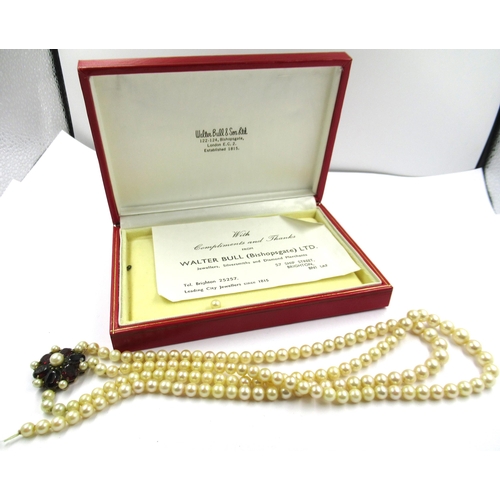 1436 - Two row cultured pearl necklace with a 9ct gold garnet set clasp