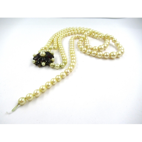 1436 - Two row cultured pearl necklace with a 9ct gold garnet set clasp