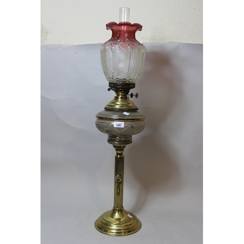 Large Early 20th Century gilt brass oil lamp with cranberry glass shade