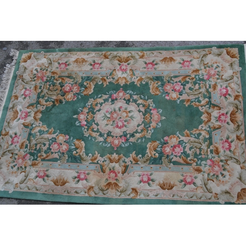 21 - Small Chinese carpet with an embossed floral design on a green ground with borders, 9ft x 6ins appro... 