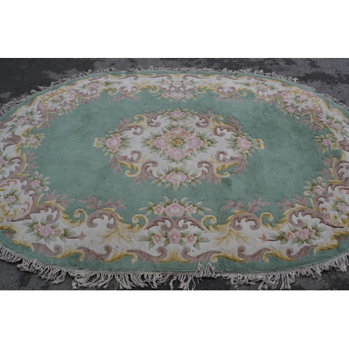 22 - Indian oval floral pattern rug with a central medallion and floral border on a green ground, 9ft x 6... 