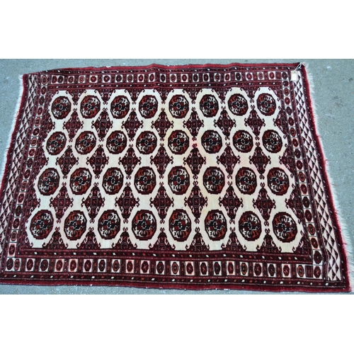 35 - Small Pakistan rug of Turkoman design with four rows of eight gols on an ivory ground with borders, ... 