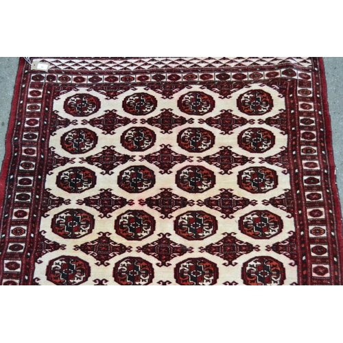 35 - Small Pakistan rug of Turkoman design with four rows of eight gols on an ivory ground with borders, ... 