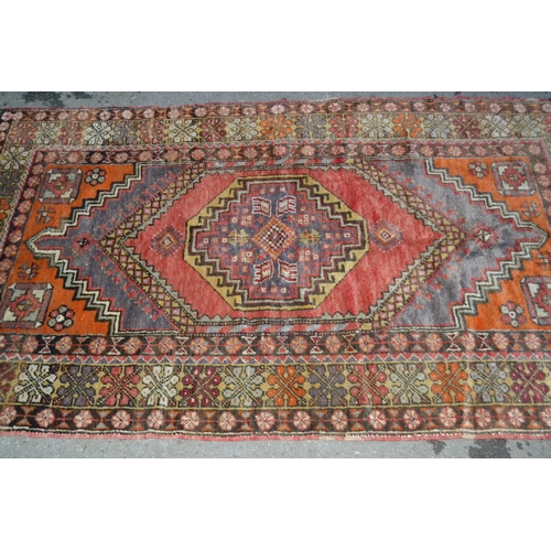 42 - Kurdish rug with central hooked medallion and multiple borders on a red and brown ground, 190 x 110c... 