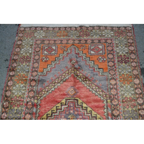 42 - Kurdish rug with central hooked medallion and multiple borders on a red and brown ground, 190 x 110c... 