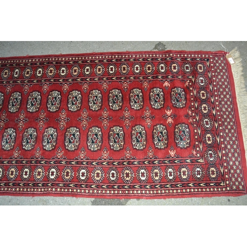 43 - Pakistan Turkoman design runner having two rows of gols with multiple borders on a red ground, 230 x... 