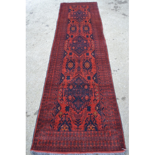 54 - Modern Afghan Belouch runner with a triple medallion and all-over design on a rust ground with multi... 