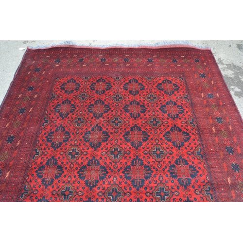 58 - Afghan carpet with four rows of seven gols on a wine ground with multiple borders, 9ft 6ins x 6ft 8i... 