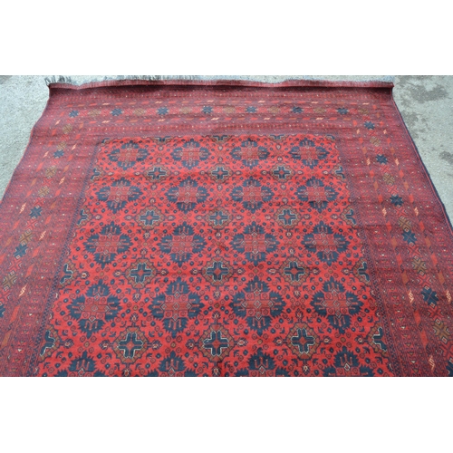58 - Afghan carpet with four rows of seven gols on a wine ground with multiple borders, 9ft 6ins x 6ft 8i... 