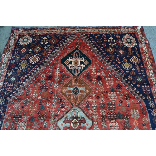 60 - Modern Qashqai carpet with a five medallion and all-over stylised floral design on a red ground, wit... 