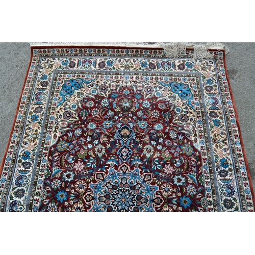 68 - Modern Qum style rug with a lobed medallion and all-over palmette design on a deep red ground, with ... 