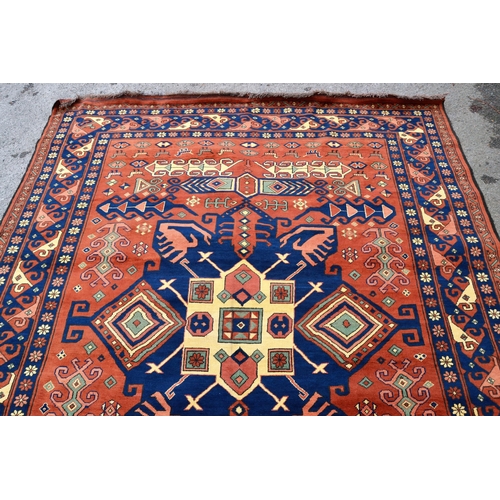 69 - Modern Kazak carpet with a central medallion and all-over stylised hooked design on a rust ground wi... 