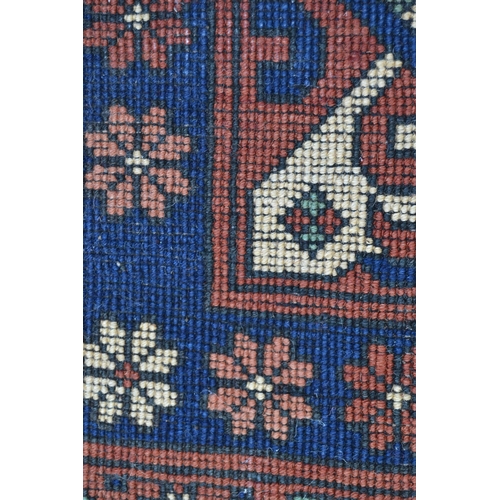 69 - Modern Kazak carpet with a central medallion and all-over stylised hooked design on a rust ground wi... 