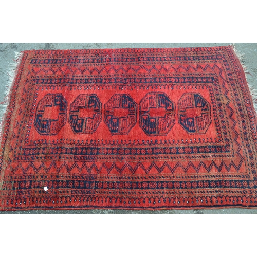77 - Small Afghan rug with a single row of four gols on a red ground with borders, 6ft x 3ft 10ins approx... 