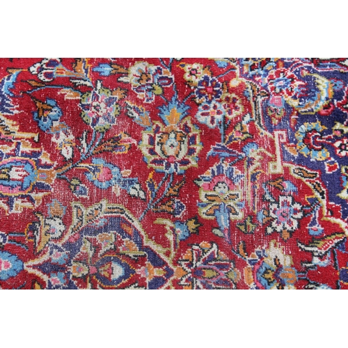 9 - Modern Kashan carpet with a medallion and all-over floral design on a red ground with borders, 9ft 8... 
