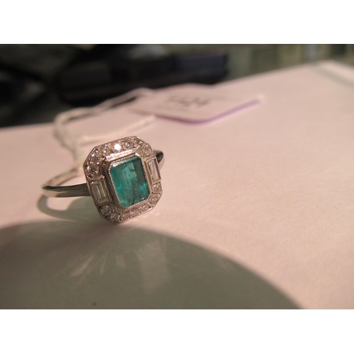 1121 - Platinum ring set with central octagonal emerald surrounded by diamonds, size N