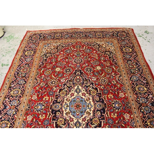 14 - Modern Kashan carpet with a lobed medallion and all-over stylised floral design, on a red ground wit... 