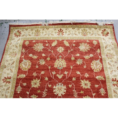 16 - Indo Persian rug of Ziegler design with an all-over palmette pattern on a red ground, with beige gro... 