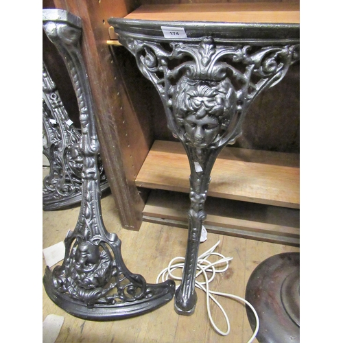 174 - Two pairs of powder coated cast iron pub table legs with mask head decoration