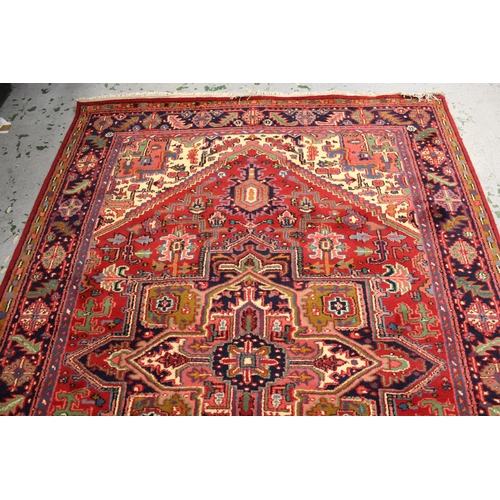 19 - Modern Heriz carpet with a typical lobed medallion and all-over stylised floral design on a red grou... 