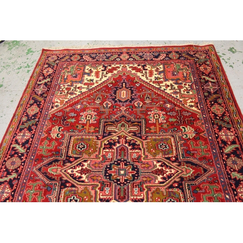 19 - Modern Heriz carpet with a typical lobed medallion and all-over stylised floral design on a red grou... 