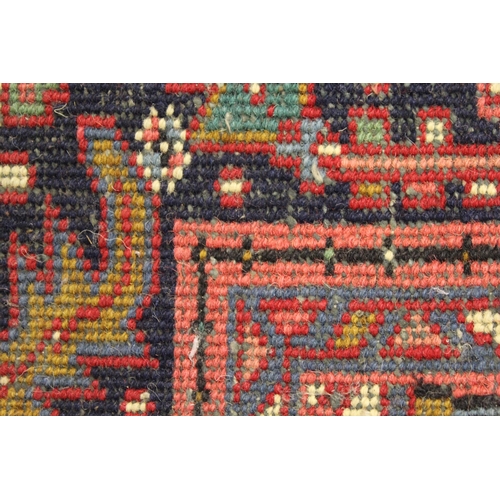 19 - Modern Heriz carpet with a typical lobed medallion and all-over stylised floral design on a red grou... 