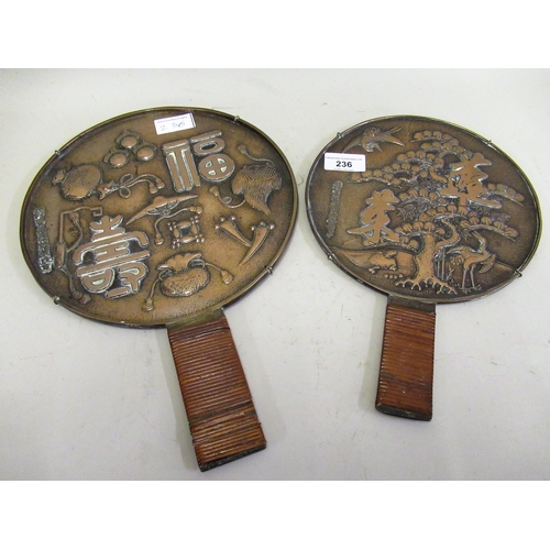 236 - Two antique Japanese bronze hand mirrors with bamboo woven handles decorated with text, charms and a... 