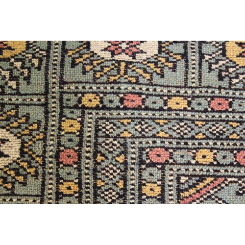 34 - Pakistan Bokhara rug with three rows of gols on a green ground with borders, 253cms x 157cms