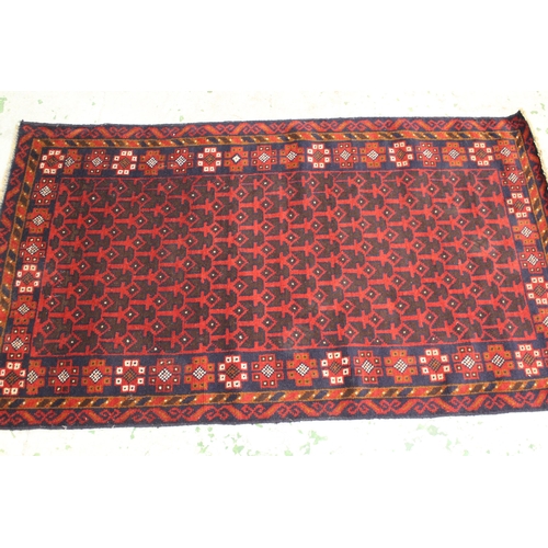 37 - Modern Afghan Belouch rug with an all-over stylised design in shades of deep red and dark blue, 200 ... 