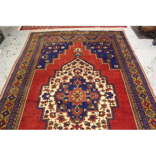 39 - Turkish carpet with a lobed medallion and plain design with red ground, blue ground corner designs a... 