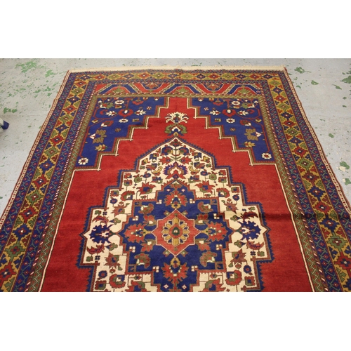 39 - Turkish carpet with a lobed medallion and plain design with red ground, blue ground corner designs a... 