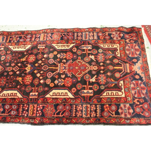 41 - Sarouk runner with a multiple vase and floral design on a dark blue ground with borders, 391 x 110cm... 