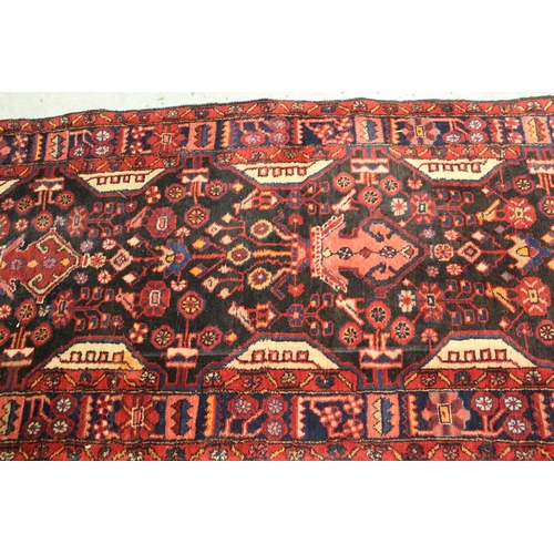 41 - Sarouk runner with a multiple vase and floral design on a dark blue ground with borders, 391 x 110cm... 