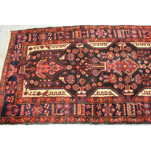 41 - Sarouk runner with a multiple vase and floral design on a dark blue ground with borders, 391 x 110cm... 