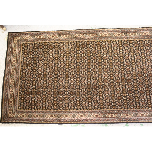 45 - Indo Persian runner with an all-over Herati design on a dark ground with narrow borders, 380cms x 74... 