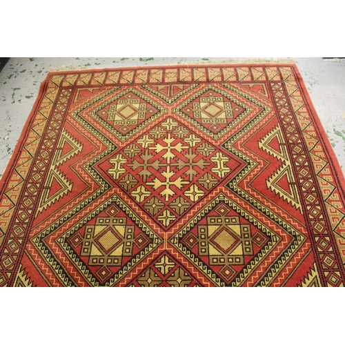 46 - Tunisian carpet with an eight geometric medallion design on a rose ground with borders, 296cms x 203... 