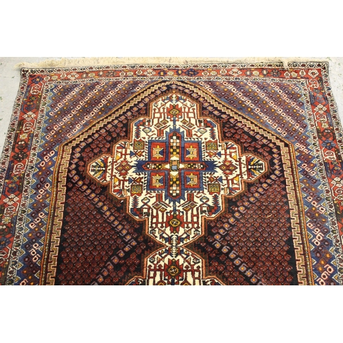 49 - Sirjan rug with a twin medallion and all-over Boteh design on a dark ground with borders and corner ... 