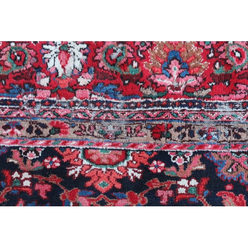 7 - Sarouk Mahal carpet with an all-over stylised flower head design, on a midnight blue ground with bor... 